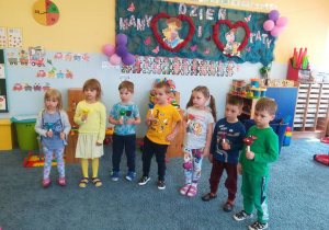 Dzieci stoją z kolorowymi dzwonkami – grają melodię „Sto lat”